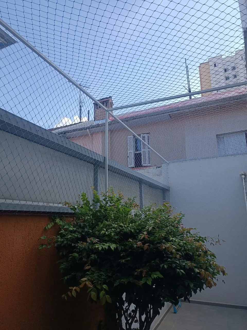 Detalhe da malha da rede de proteção no batente da janela